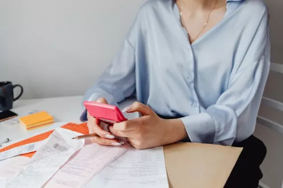 Woman sitting on desk making calculation